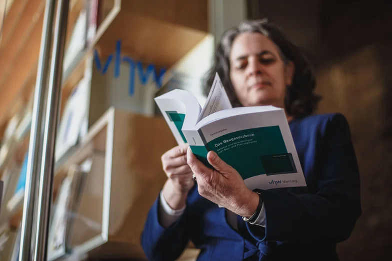 vhw-Fachbücher Eine Frau liest in einem Buch des vhw Verlags.